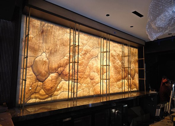 Backlit onyx wall behind the bar